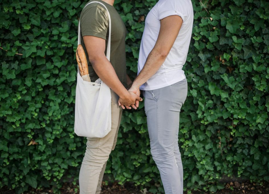 two men standing face to face and holding hands
