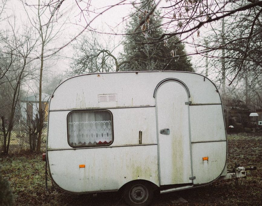 white vintage caravan parked on grass field