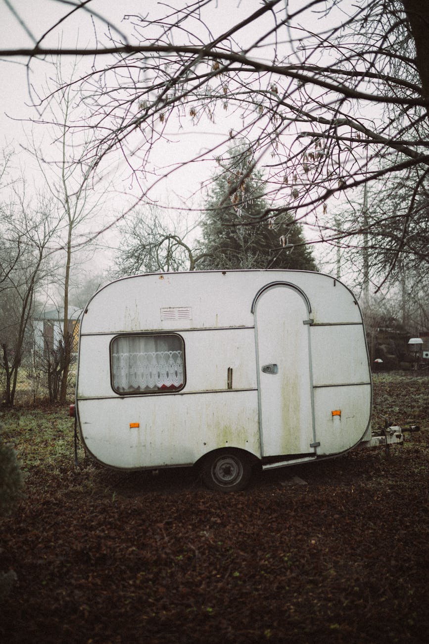 white vintage caravan parked on grass field